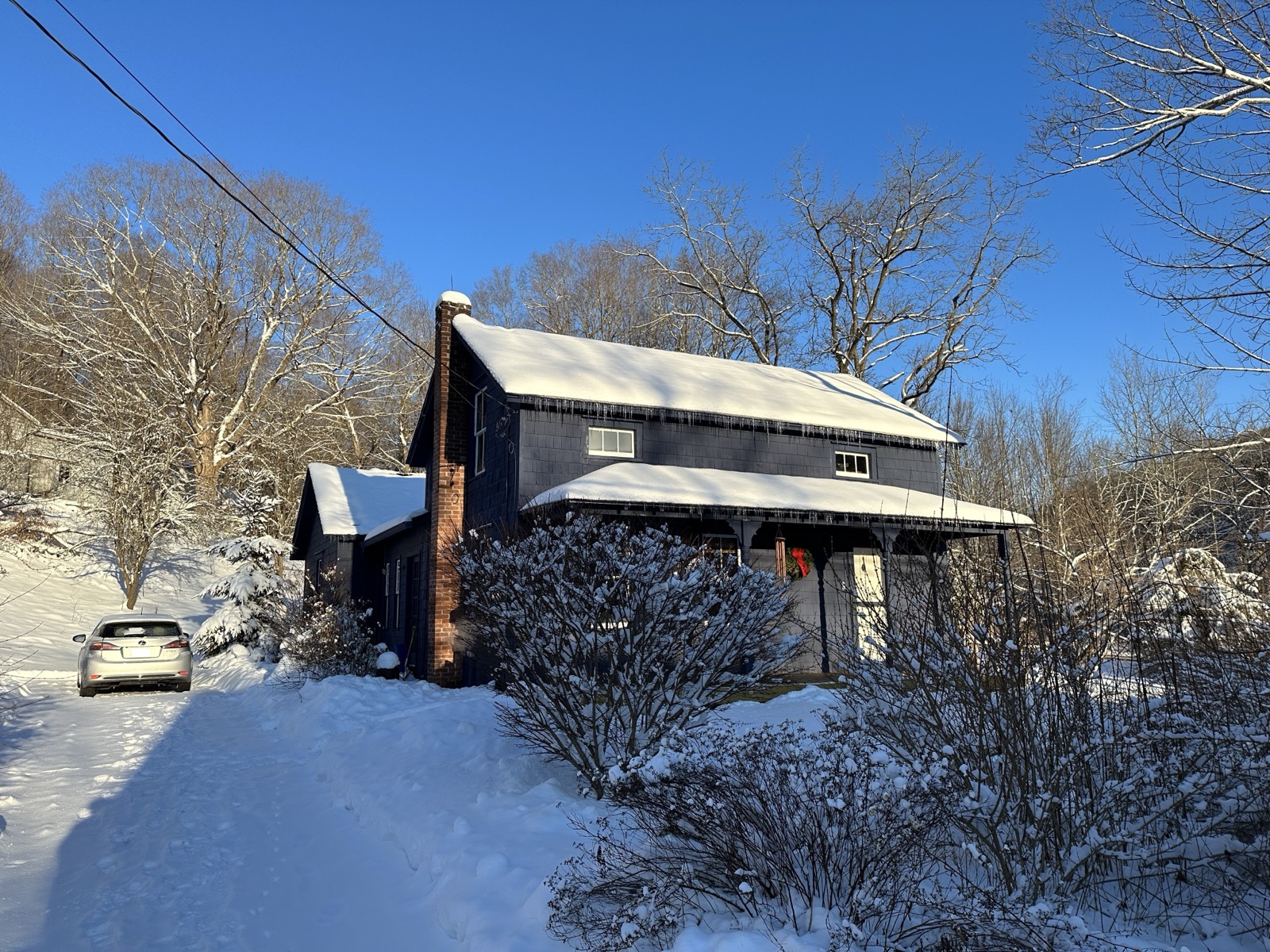 View of house from driveway covered in snow